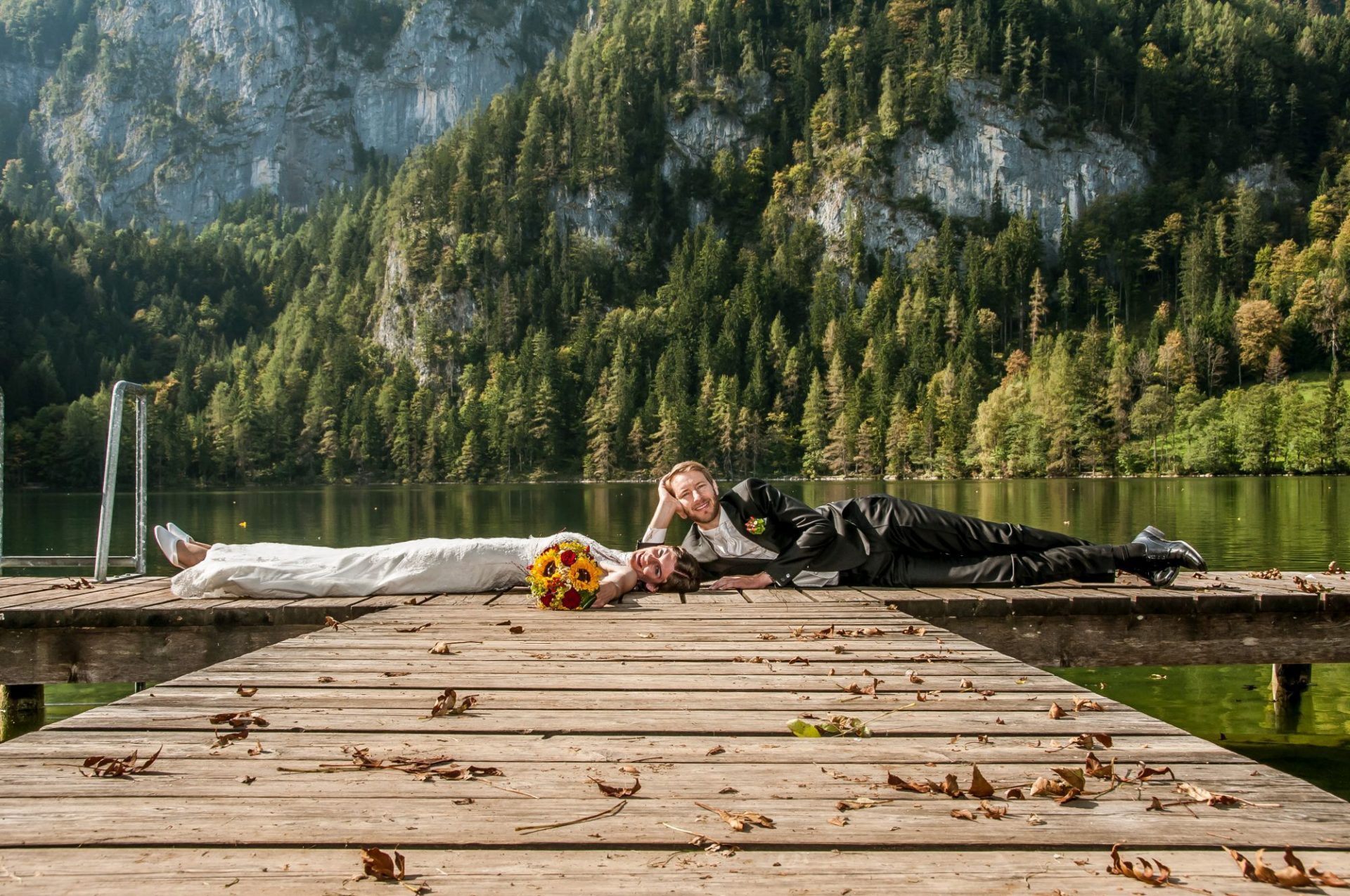 Paar liegt auf Steg vor kleinem See